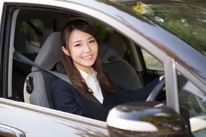 若い女性が車の運転席に座っている画像